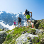 Trail runners running up a steep trail in the Alps in summer
